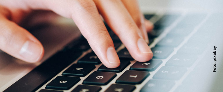 Eine Hand tippt auf einer Tastatur